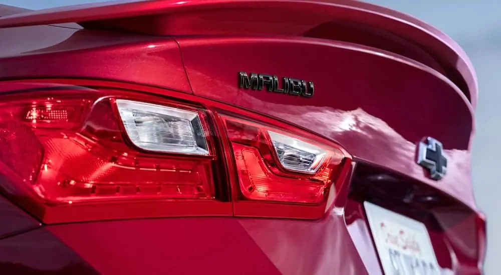 A close up view of the rear badging on a red 2021 Chevy Malibu.
