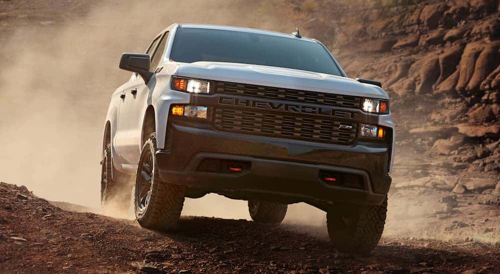 A white 2021 Chevy Silverado 1500 is off-roading on dirt.