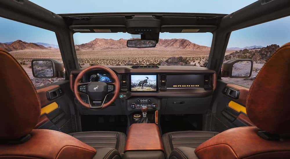The black, brown, and yellow interior is shown on a 2021 Ford Bronco looking out at the desert after winning the 2021 Ford Bronco vs 2021 Toyota 4Runner comparison.