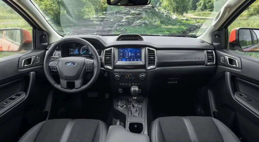 The black interior is shown from the back seat on a 2021 Ford Ranger Tremor Lariat.