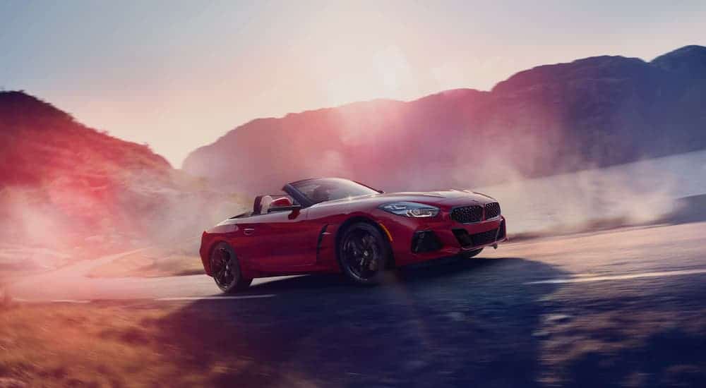 A red 2021 BMW Z4 M40i is driving down a misty road.
