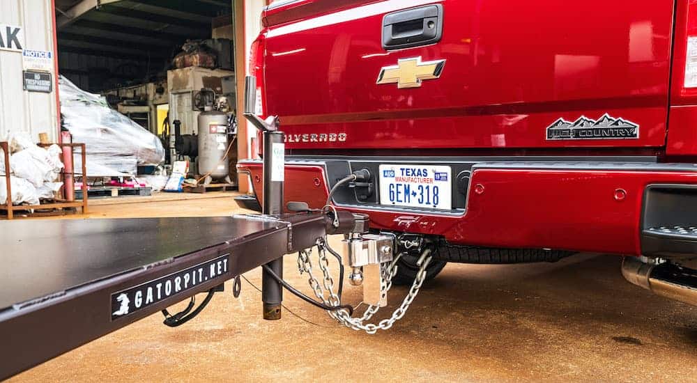 A close up is shown of the tow hitch and chains on a red 2019 used Chevy Silverado 1500 High Country.