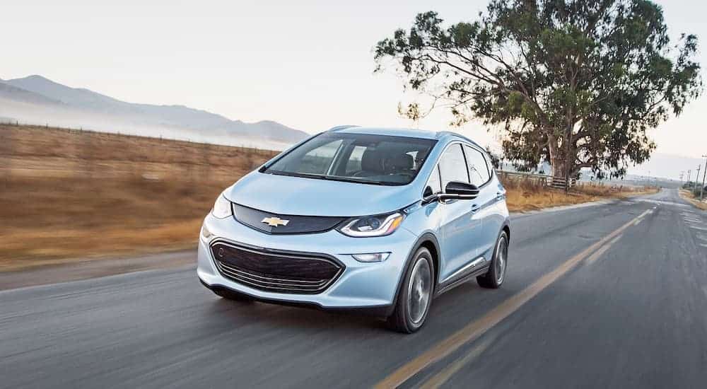 A silver 2017 Chevy Bolt EV is driving down the highway.