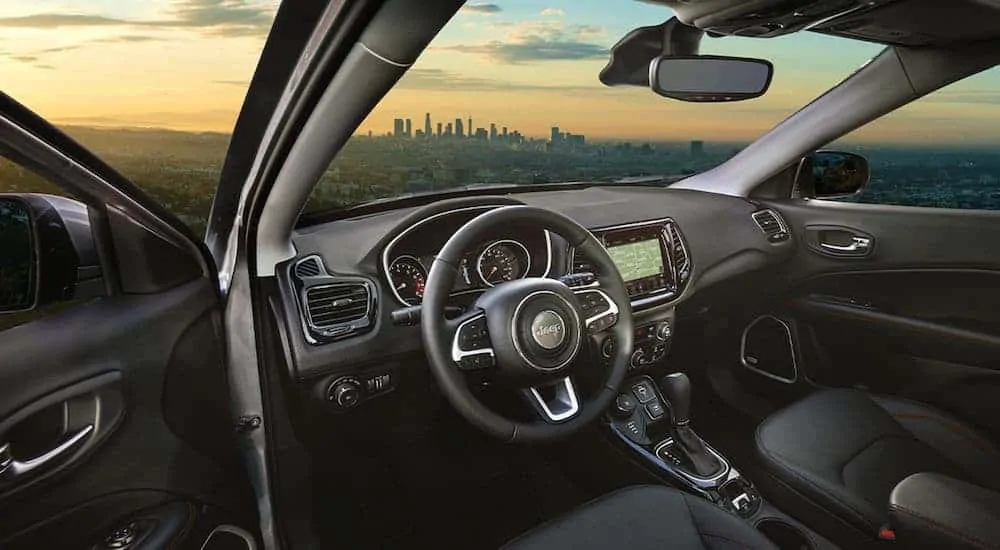 The black interior is shown on the 2021 Jeep Compass overlooking a city.