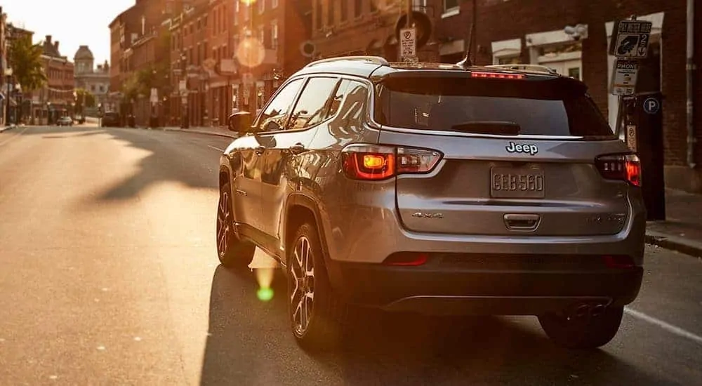 A grey 2021 Jeep Compass is parked on a city street after leaving a Jeep dealer near you.
