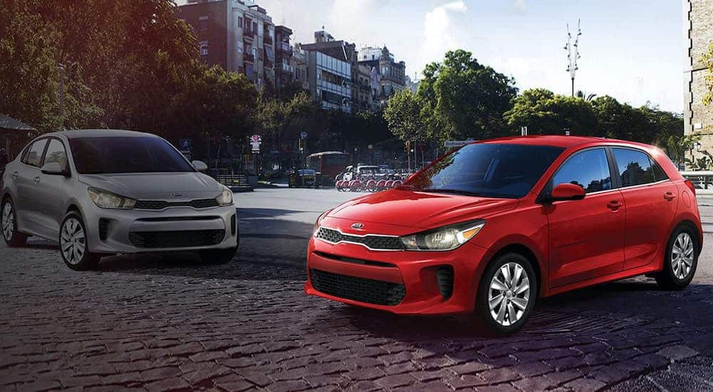 A popular Kia model, A white and a red 2021 Kia Rio are parked in the city.
