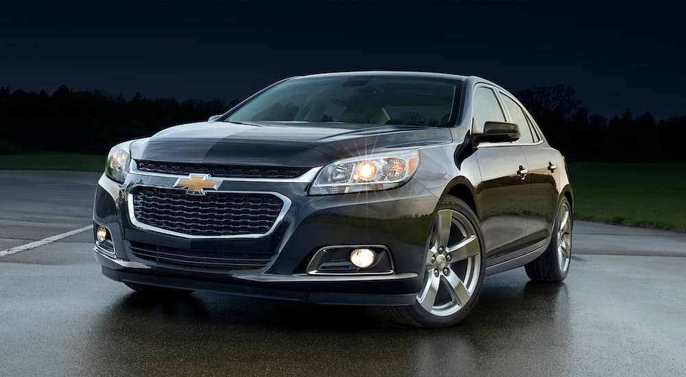 A black 2015 used Chevy Malibu is shown from the front angled left.