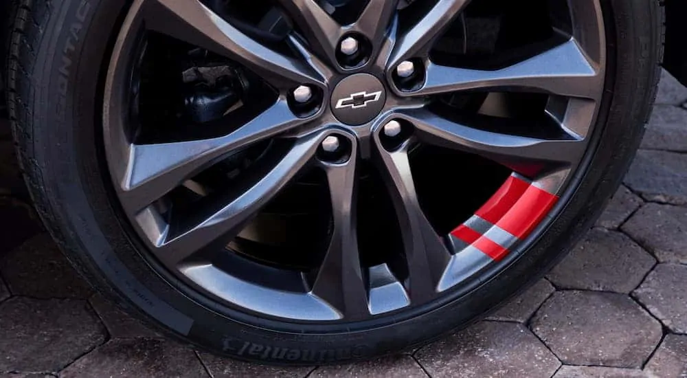 A close up is shown on the wheel of a 2016 used Chevy Malibu Redline.