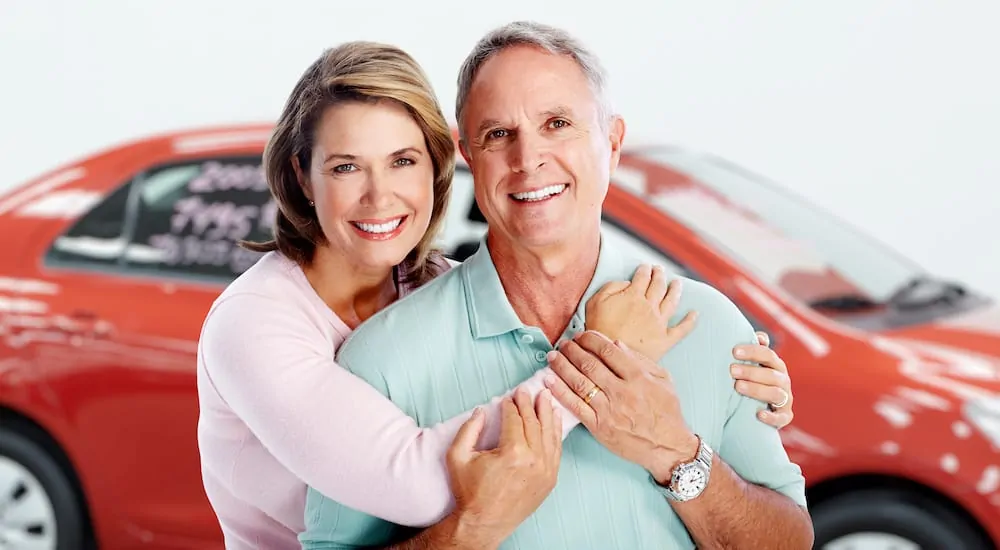 An older couple excited over their new car