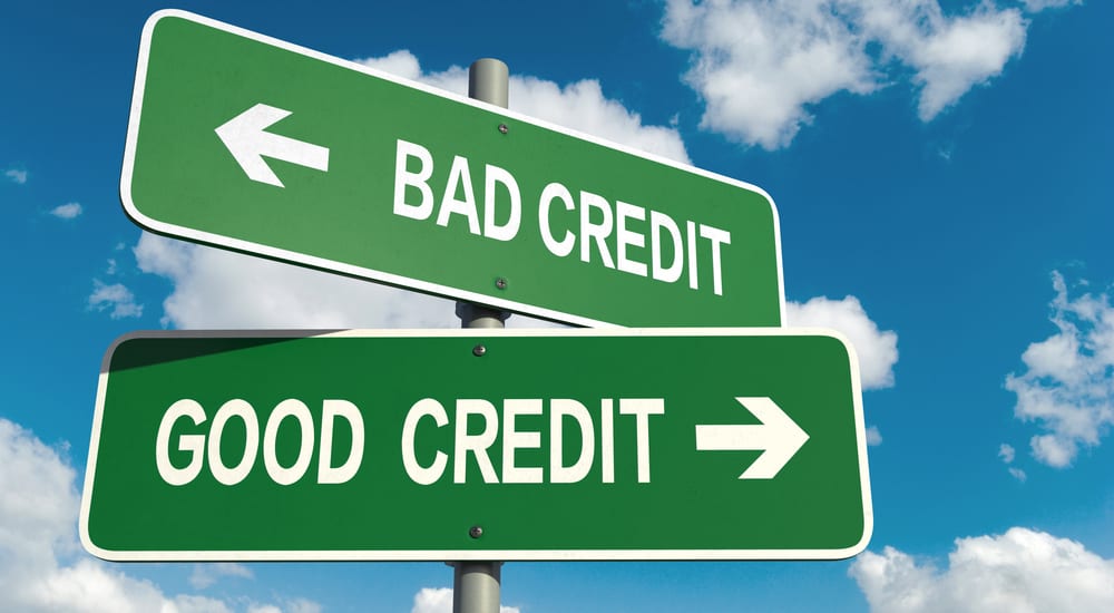 Two green signs facing in opposite directions, one saying "bad credit" the other, "good credit"