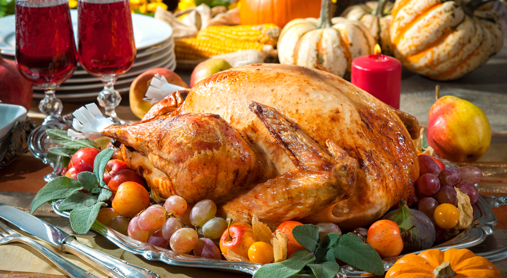 Thanksgiving dinner. Roasted turkey on holiday table with pumpkins, flowers and wine