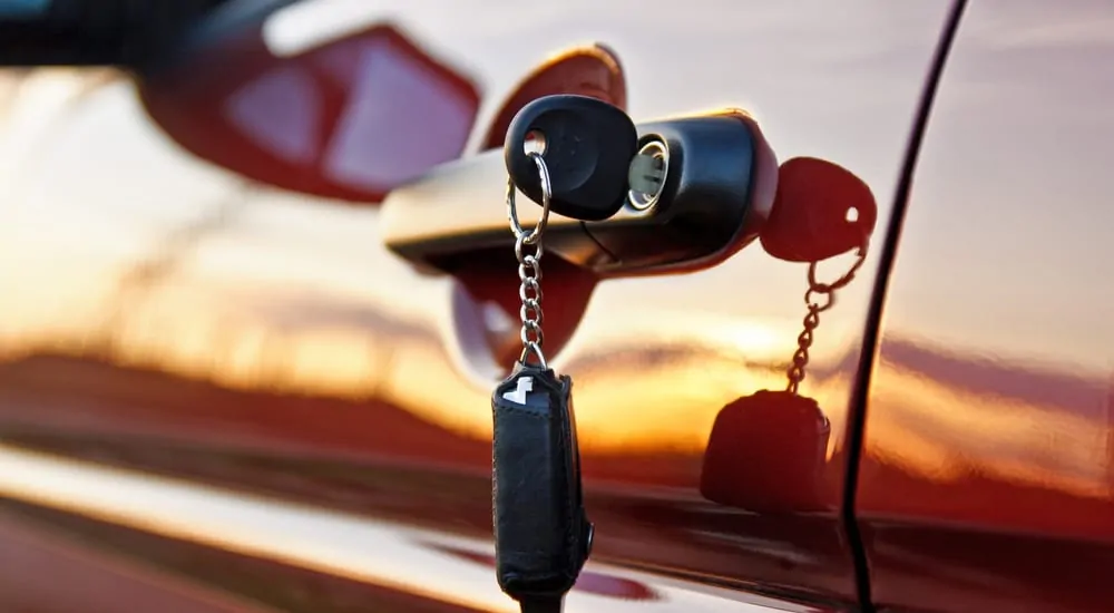 Keys hanging out of a red car door