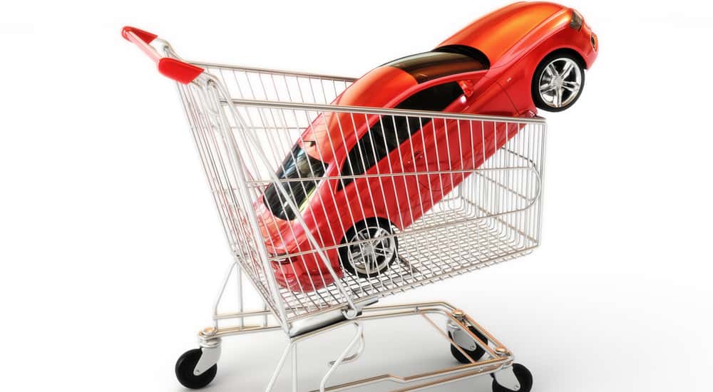 Orange-red car in a silver and red shopping cart