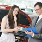 Millennial Buying Used at a Car Dealership with Salesman in Colorado