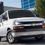 A popular cargo van for sale near me. a white 2014 Chevy Express cargo van, parked on a parking lot.