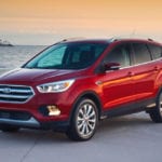 A red 2017 Ford Escape on a beach at sunset