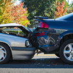 Side profile of silver sedan smashed into a black sedan