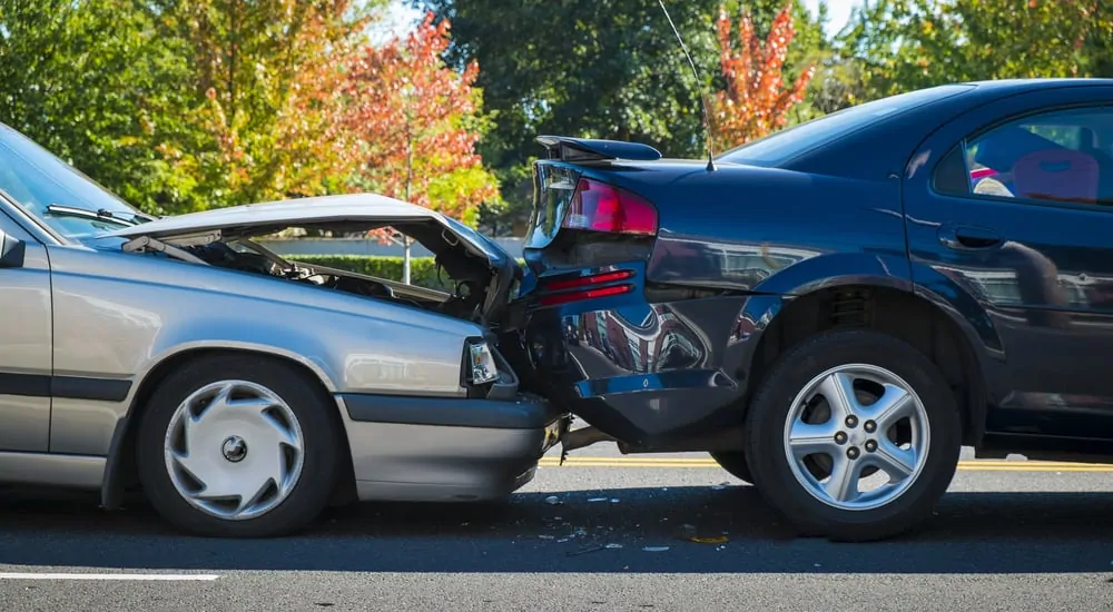 Side profile of silver sedan smashed into a black sedan