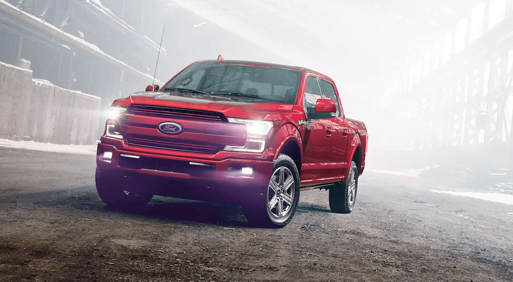 A red 2018 Ford F-150 at a snowy, misty construction site