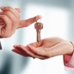 Man handing a women a set of keys