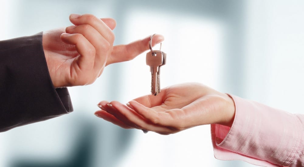 Man handing a women a set of keys