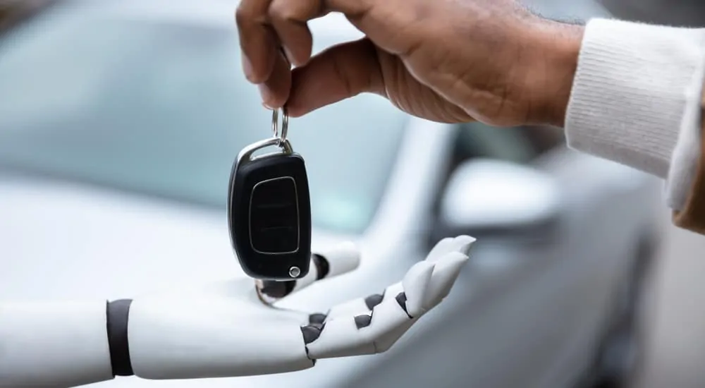 Close up of man handing a white and black robot car keys