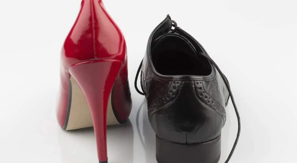 High heel and black mens dress shoe representing stark comparison