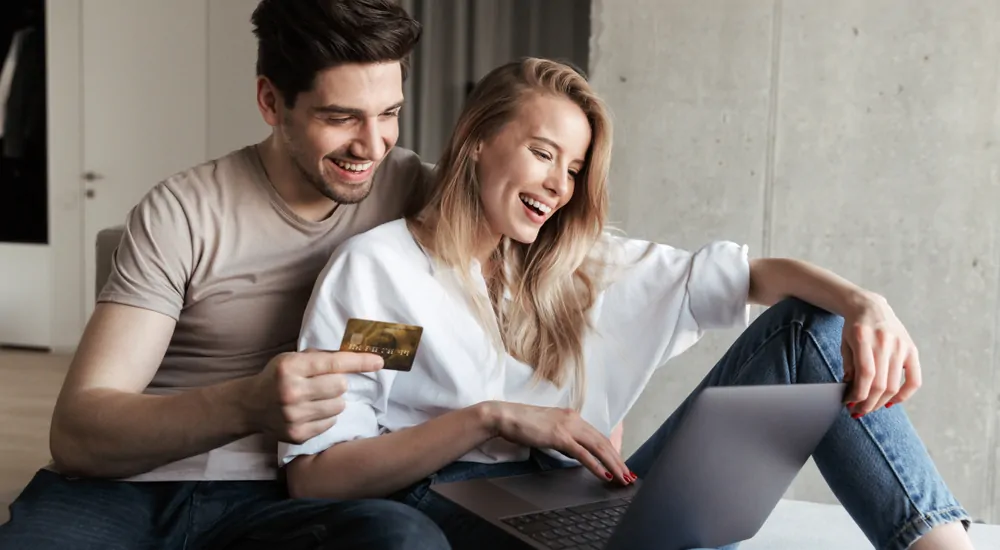 A cute couple shopping for vehicles on their mac laptop