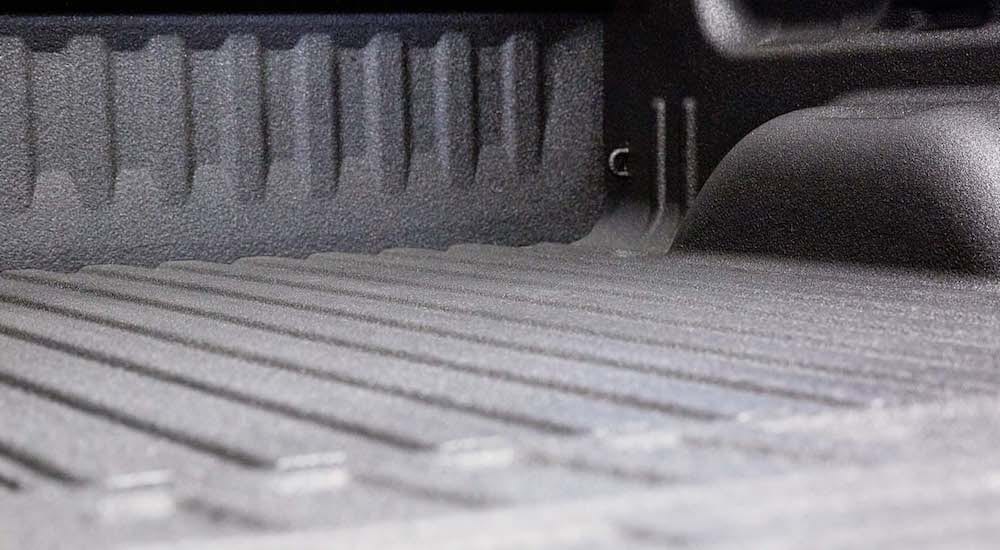 A close up shows a truck bed equipped with a liner.