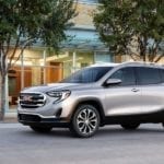 Silver 2018 GMC Terrain in front of building with trees