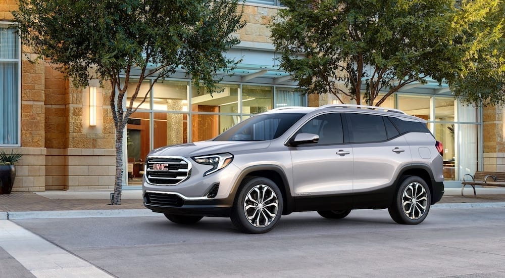 Silver 2018 GMC Terrain in front of building with trees