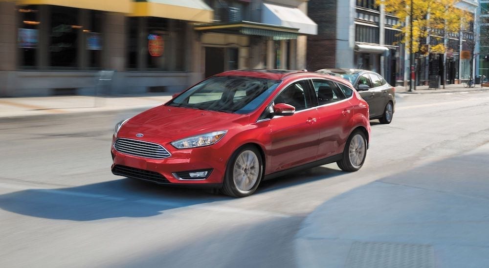 A red Ford Fiesta driving on a city street, get your own with Ford Lease Deals