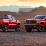 2 Red 2018 Chevy Silverados in front of a canyon at sunset