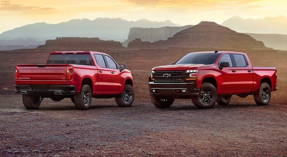 2 Red 2018 Chevy Silverados in front of a canyon at sunset