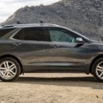 Gray 2019 Chevy Equinox at beach with liftgate open and mountains in background