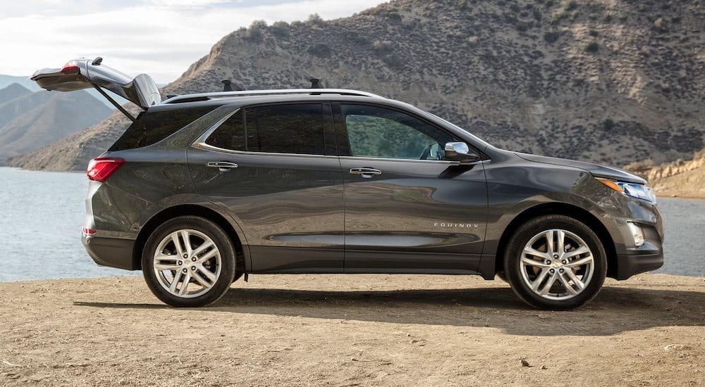 Gray 2019 Chevy Equinox at beach with liftgate open and mountains in background