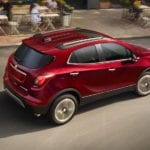 Red 2019 Buick Encore driving by cafe