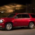 Red 2019 Chevy Tahoe driving at night