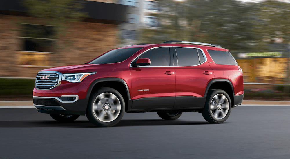 Red 2019 GMC Acadia driving on street