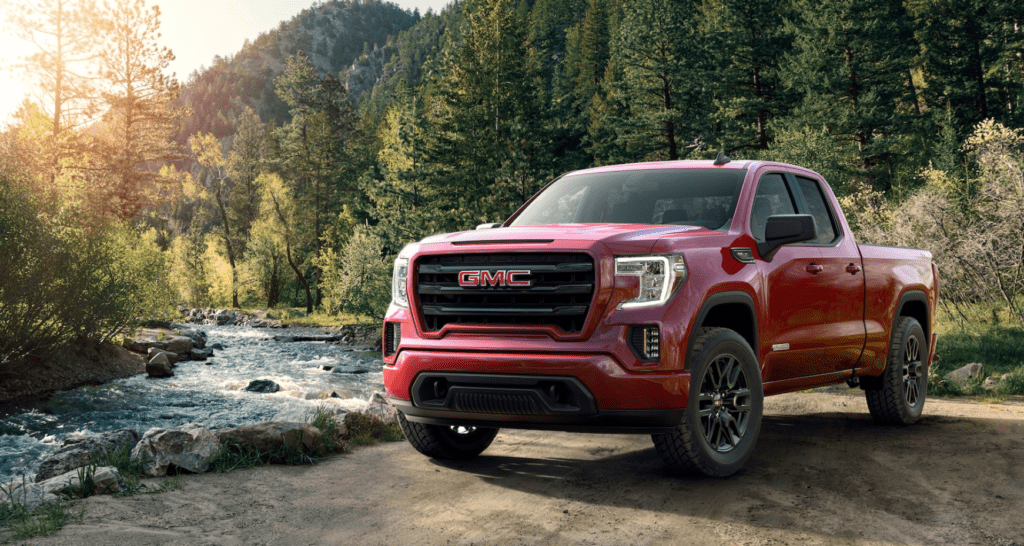 Red 2019 GMC Sierra 1500 with woodland river in back