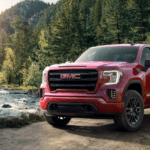 Red 2019 GMC Sierra 1500 with woodland river in back