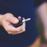Closeup of hand with car key, rest of body is out of focus