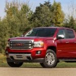 Red 2019 GMC Canyon in field with trees in back