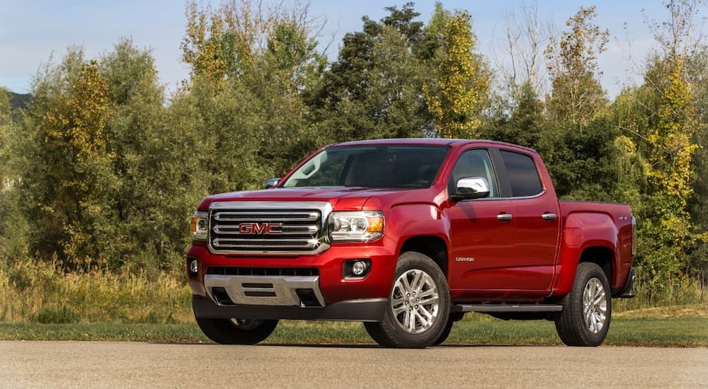 Red 2019 GMC Canyon in field with trees in back