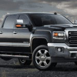 Black 2019 GMC Sierra 2500HD in field with satellite receivers