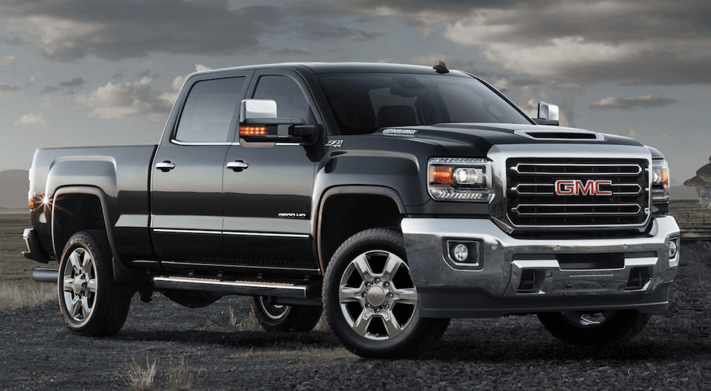 Black 2019 GMC Sierra 2500HD in field with satellite receivers