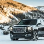 Black 2019 GMC Yukon Denali in snow covered mountains