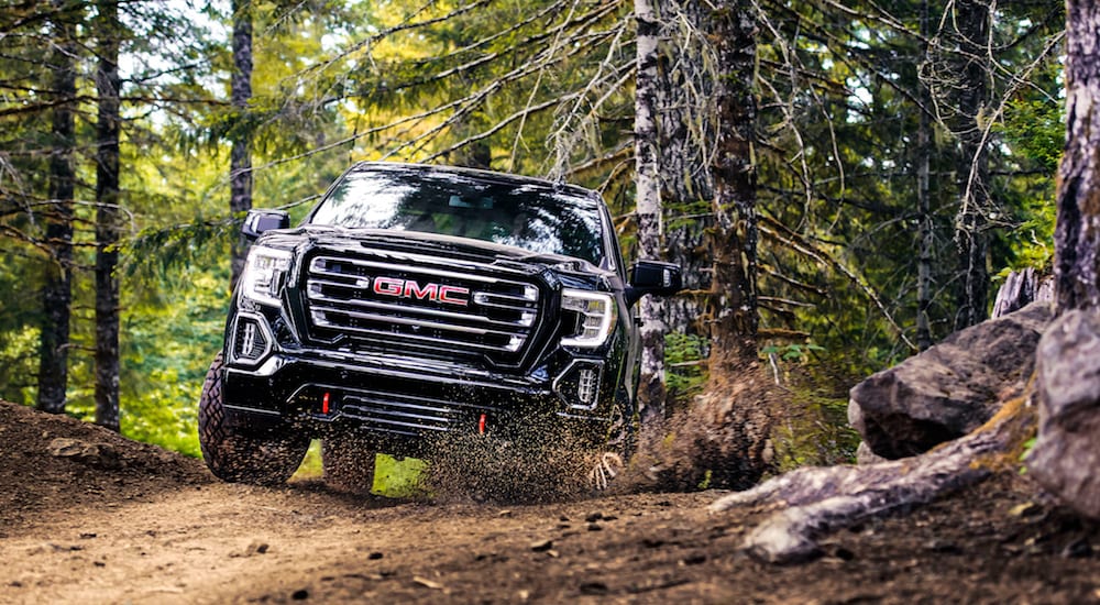 A black 2019 GMC Sierra off-roads and a small dirt trail