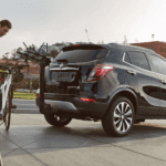 A man about to load a bike onto a black 2019 Buick Encore