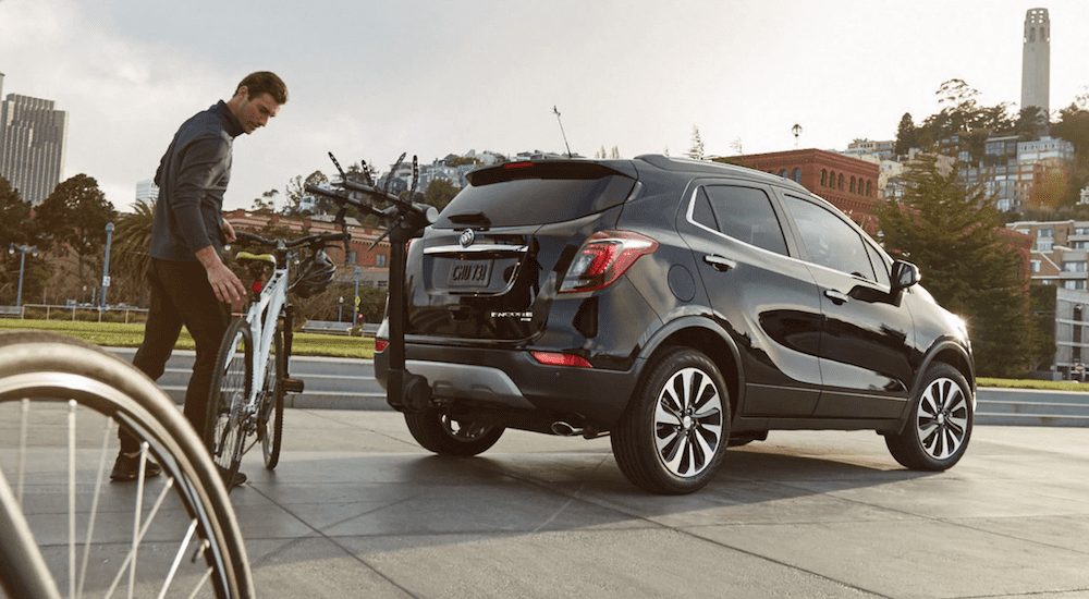 A man about to load a bike onto a black 2019 Buick Encore